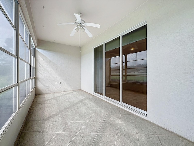 unfurnished sunroom featuring ceiling fan