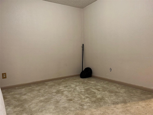 spare room with a textured ceiling and light colored carpet