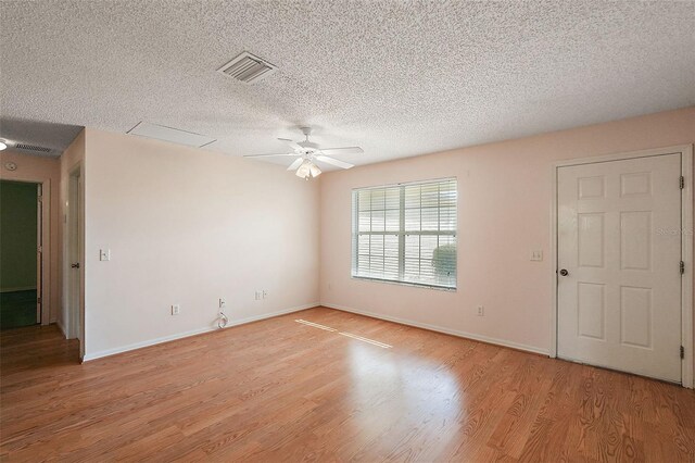 spare room with ceiling fan, a textured ceiling, and light wood-type flooring