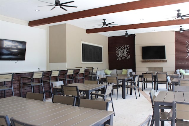 dining space with beam ceiling and ceiling fan