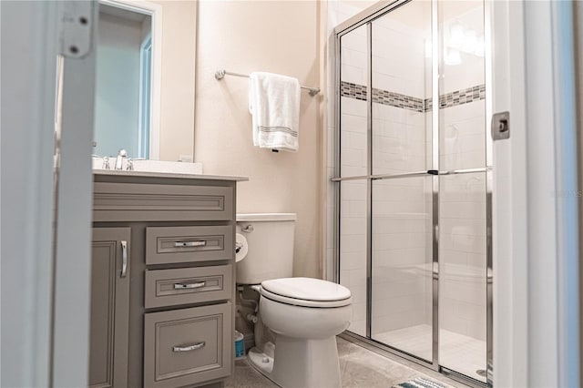 bathroom with vanity, toilet, and a shower with door