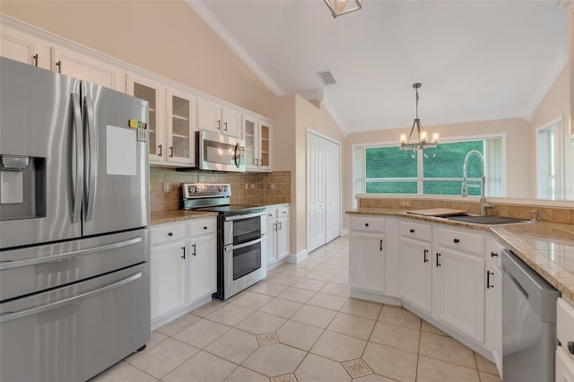 kitchen with white cabinets, stainless steel appliances, and lofted ceiling