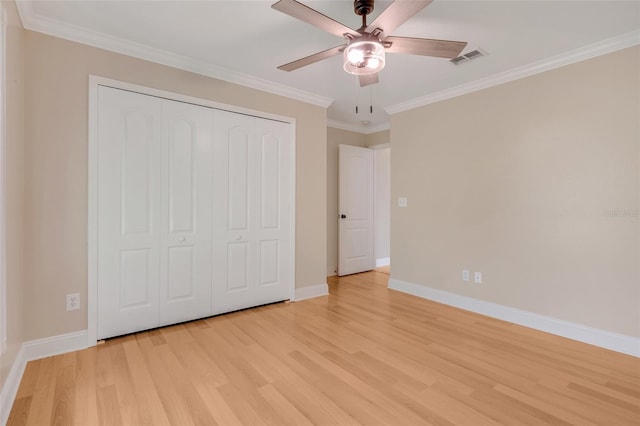 unfurnished bedroom featuring a closet, light hardwood / wood-style flooring, ceiling fan, and ornamental molding