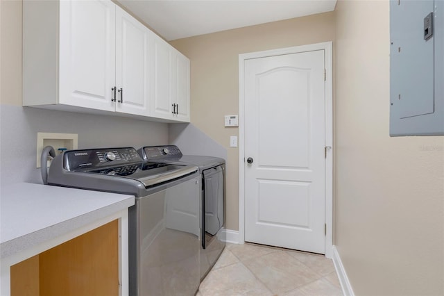 clothes washing area featuring electric panel, light tile patterned flooring, cabinets, and washing machine and dryer