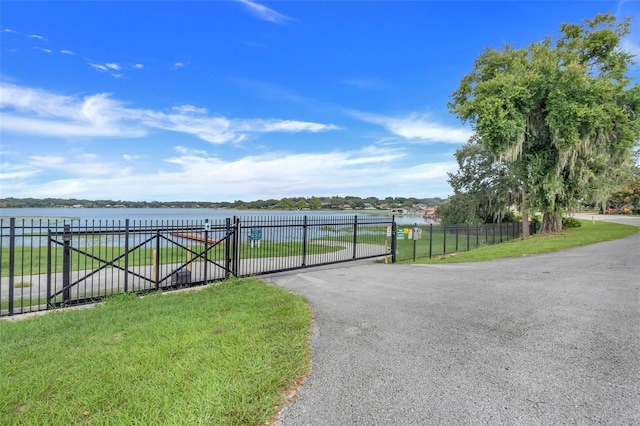 view of gate featuring a yard and a water view