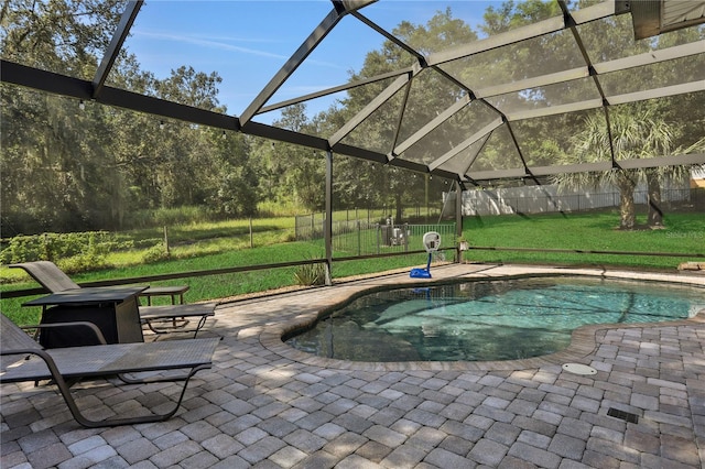 view of pool with glass enclosure, a patio area, and a yard