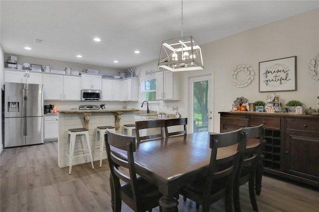 dining space featuring sink and light hardwood / wood-style floors