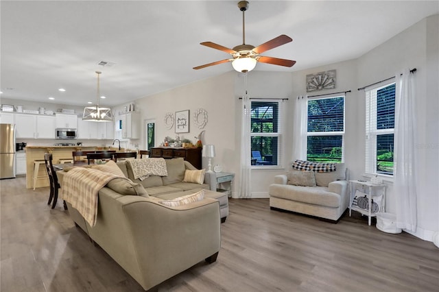 living room featuring hardwood / wood-style floors and ceiling fan with notable chandelier