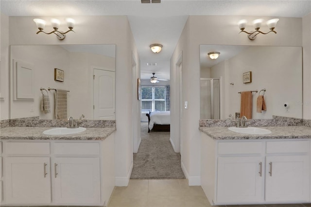 bathroom with tile patterned flooring, ceiling fan, a shower with door, and vanity