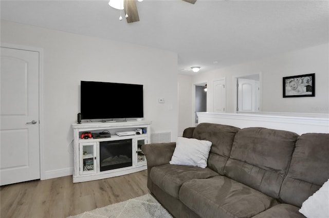 living room featuring ceiling fan and light hardwood / wood-style floors