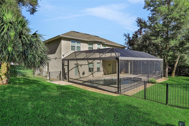 rear view of house with a lawn, glass enclosure, a patio, and a swimming pool