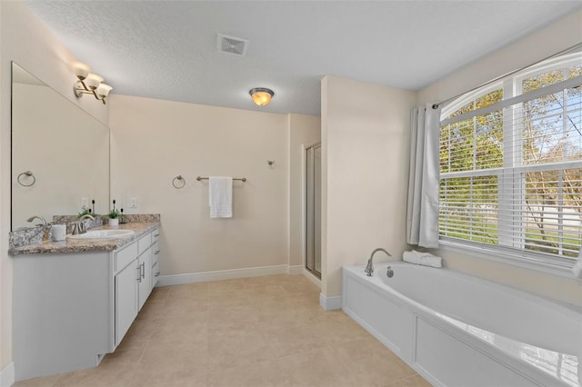 full bath with a garden tub, vanity, visible vents, baseboards, and a stall shower