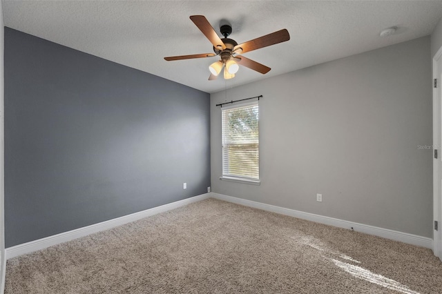 carpeted empty room with a ceiling fan, a textured ceiling, and baseboards