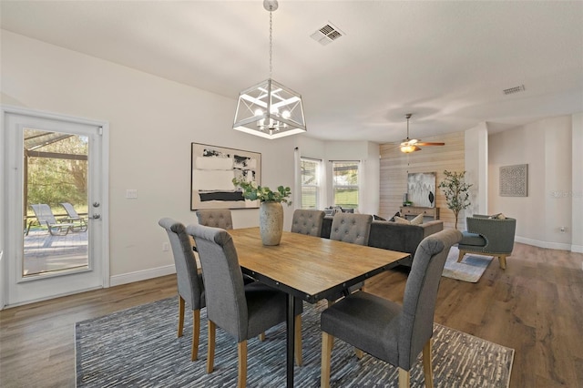 dining space with baseboards, visible vents, and wood finished floors