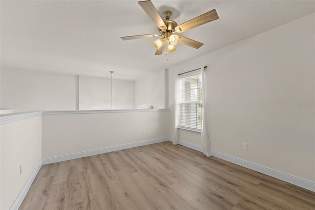 empty room with light wood-style floors, baseboards, and a ceiling fan