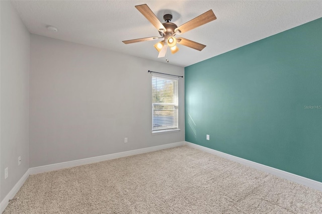 carpeted empty room featuring a ceiling fan, a textured ceiling, and baseboards