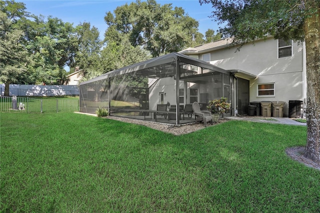 rear view of house featuring stucco siding, fence, a lawn, and a patio