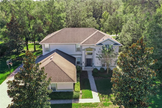 view of front of property featuring roof with shingles and stucco siding