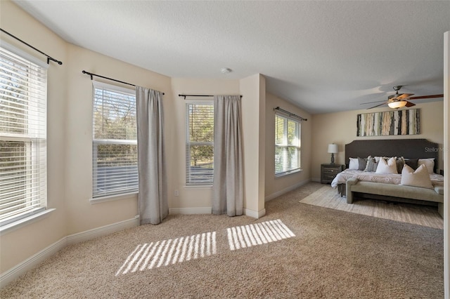 carpeted bedroom with a textured ceiling and baseboards