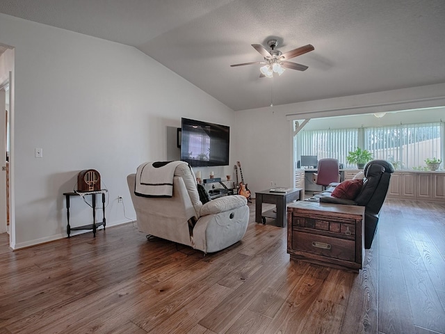 living room with lofted ceiling, ceiling fan, hardwood / wood-style flooring, and a textured ceiling