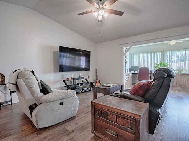 living room with light hardwood / wood-style flooring, vaulted ceiling, and ceiling fan