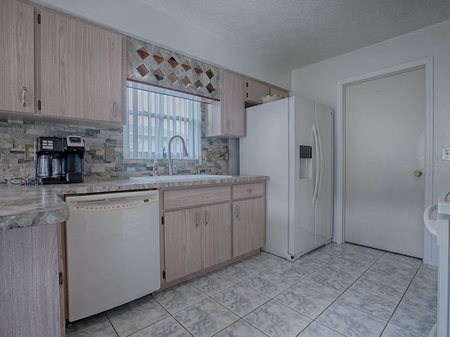 kitchen featuring tasteful backsplash, white appliances, a textured ceiling, light brown cabinetry, and sink