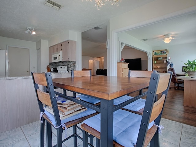 dining area with ceiling fan, a textured ceiling, and light wood-type flooring