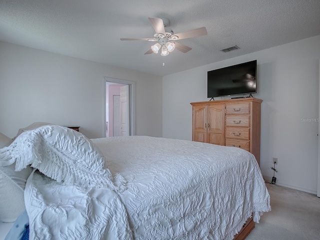 carpeted bedroom featuring ceiling fan and a textured ceiling