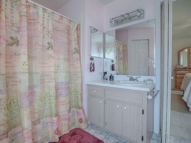 bathroom featuring tile patterned flooring, vanity, and curtained shower