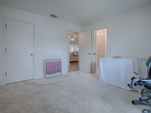 office space featuring ceiling fan, a textured ceiling, and light carpet