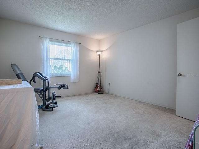 workout room featuring carpet floors and a textured ceiling