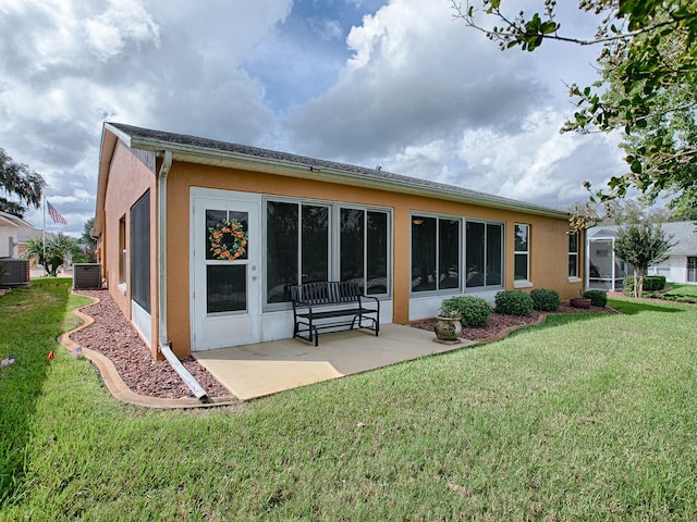 back of property featuring a lawn, a patio, and central air condition unit