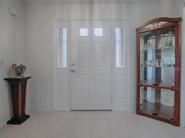 entryway with a textured ceiling and light tile patterned flooring