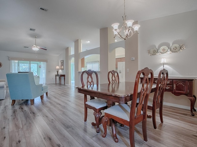 dining space featuring ceiling fan with notable chandelier and light hardwood / wood-style floors