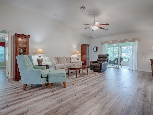 living room featuring ceiling fan, light hardwood / wood-style floors, and vaulted ceiling