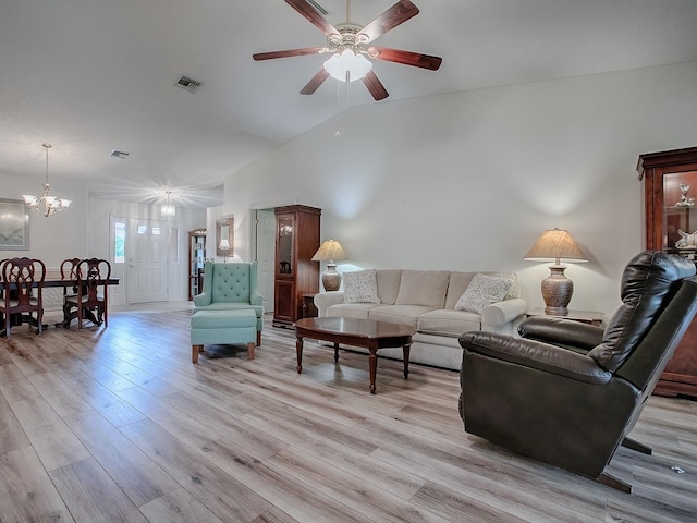 living room with ceiling fan with notable chandelier, light wood-type flooring, and vaulted ceiling