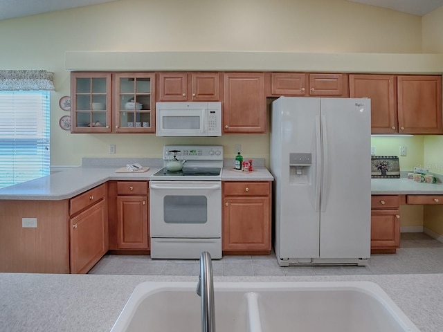 kitchen featuring light tile patterned flooring, lofted ceiling, sink, and white appliances