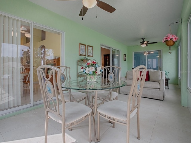 dining space featuring ceiling fan and light tile patterned floors