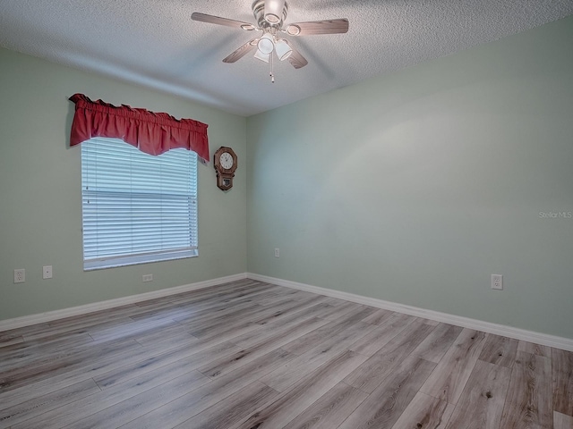 empty room with a textured ceiling, ceiling fan, and light hardwood / wood-style flooring