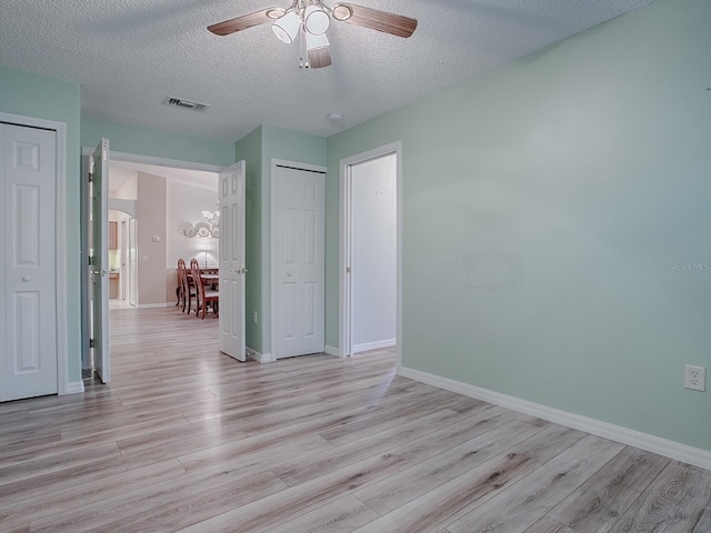 interior space featuring ceiling fan, a textured ceiling, and light wood-type flooring