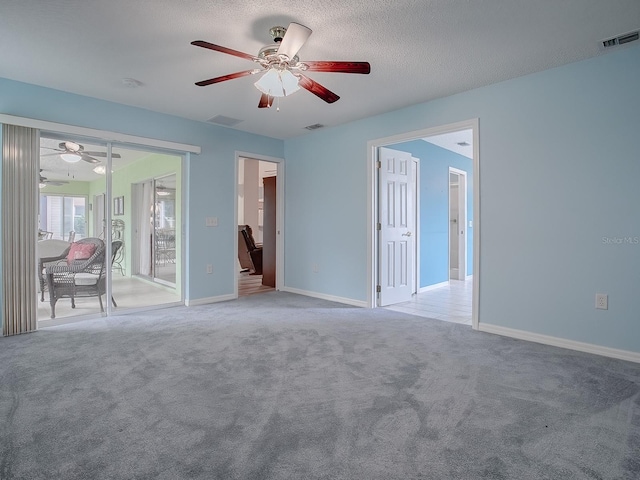 carpeted empty room with a textured ceiling and ceiling fan