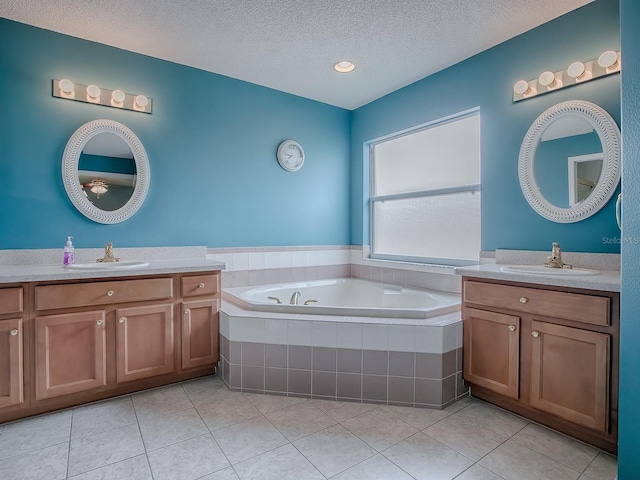 bathroom featuring vanity, a relaxing tiled tub, and tile patterned flooring