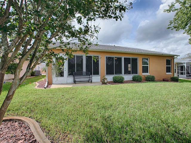 back of house with a yard, a sunroom, and central AC unit