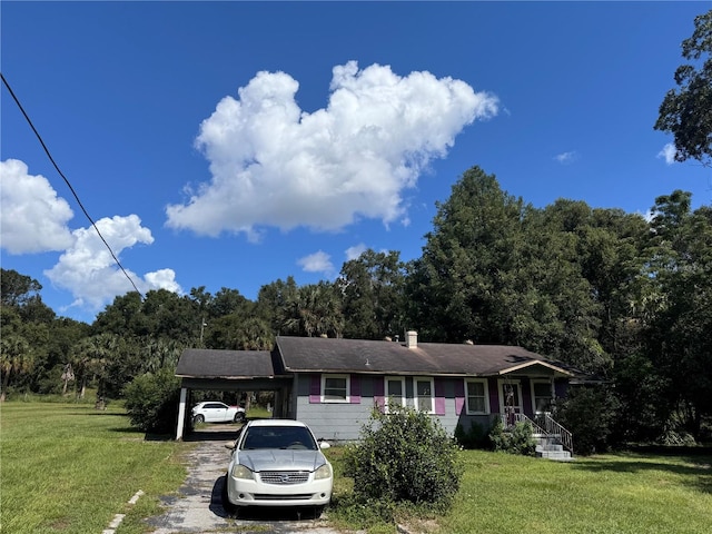 view of front of property with a front lawn and a carport