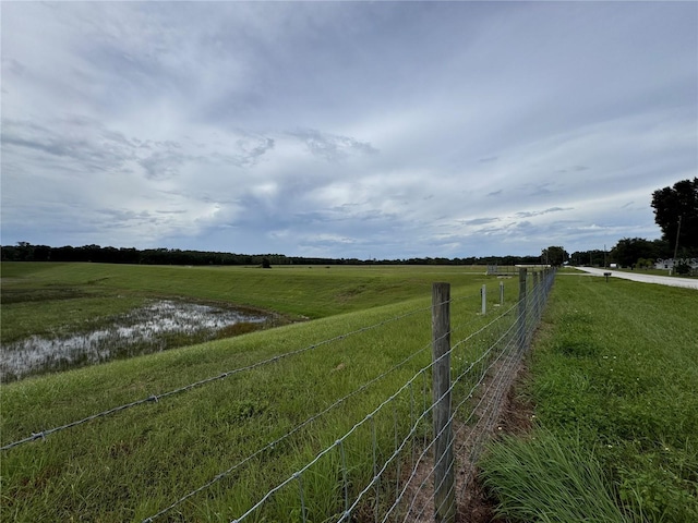 view of yard with a rural view and a water view