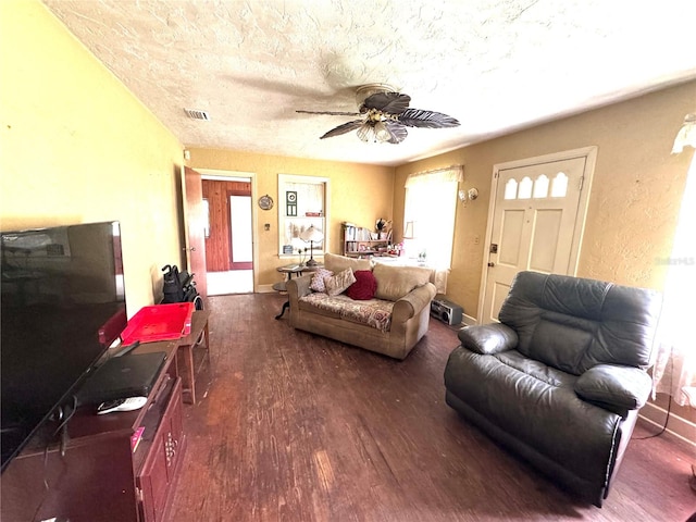 living room featuring a textured ceiling, ceiling fan, and dark hardwood / wood-style flooring