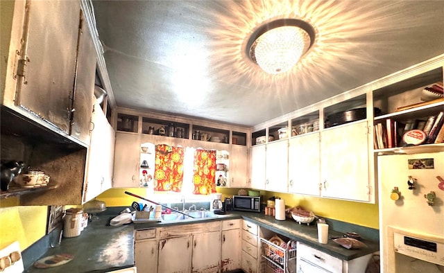 kitchen with white cabinets, sink, and white refrigerator