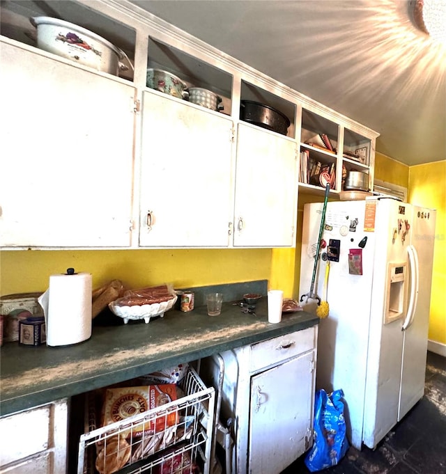 kitchen with white fridge with ice dispenser and white cabinetry