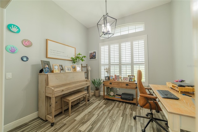 office with wood-type flooring, lofted ceiling, and a chandelier