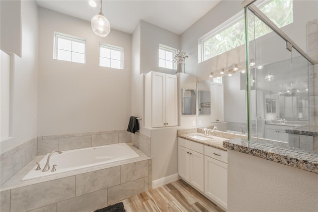 bathroom with independent shower and bath, vanity, and hardwood / wood-style flooring